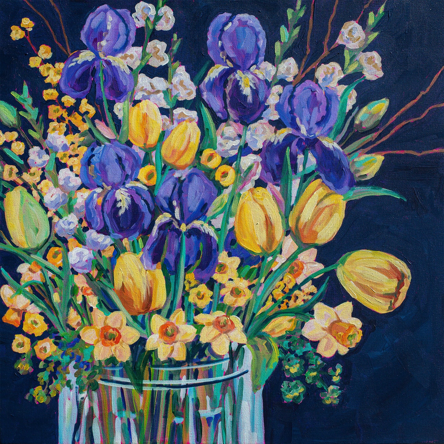 Colorful bouquet of flowers including tulips and irises in a clear vase on a dark background
