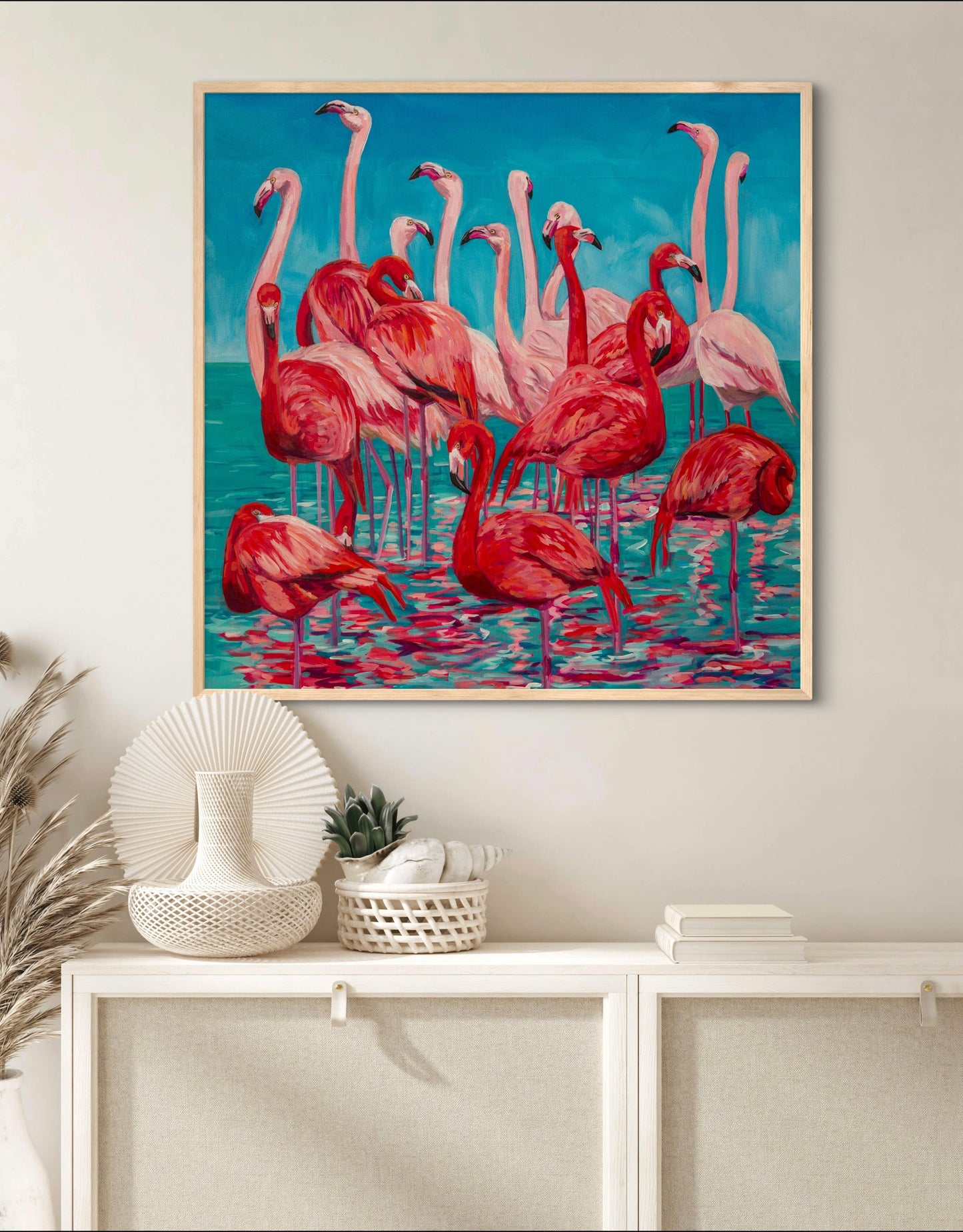cool beach coastal room with white shelf and vibrant statement painting of a grouping of flamingos in the water.