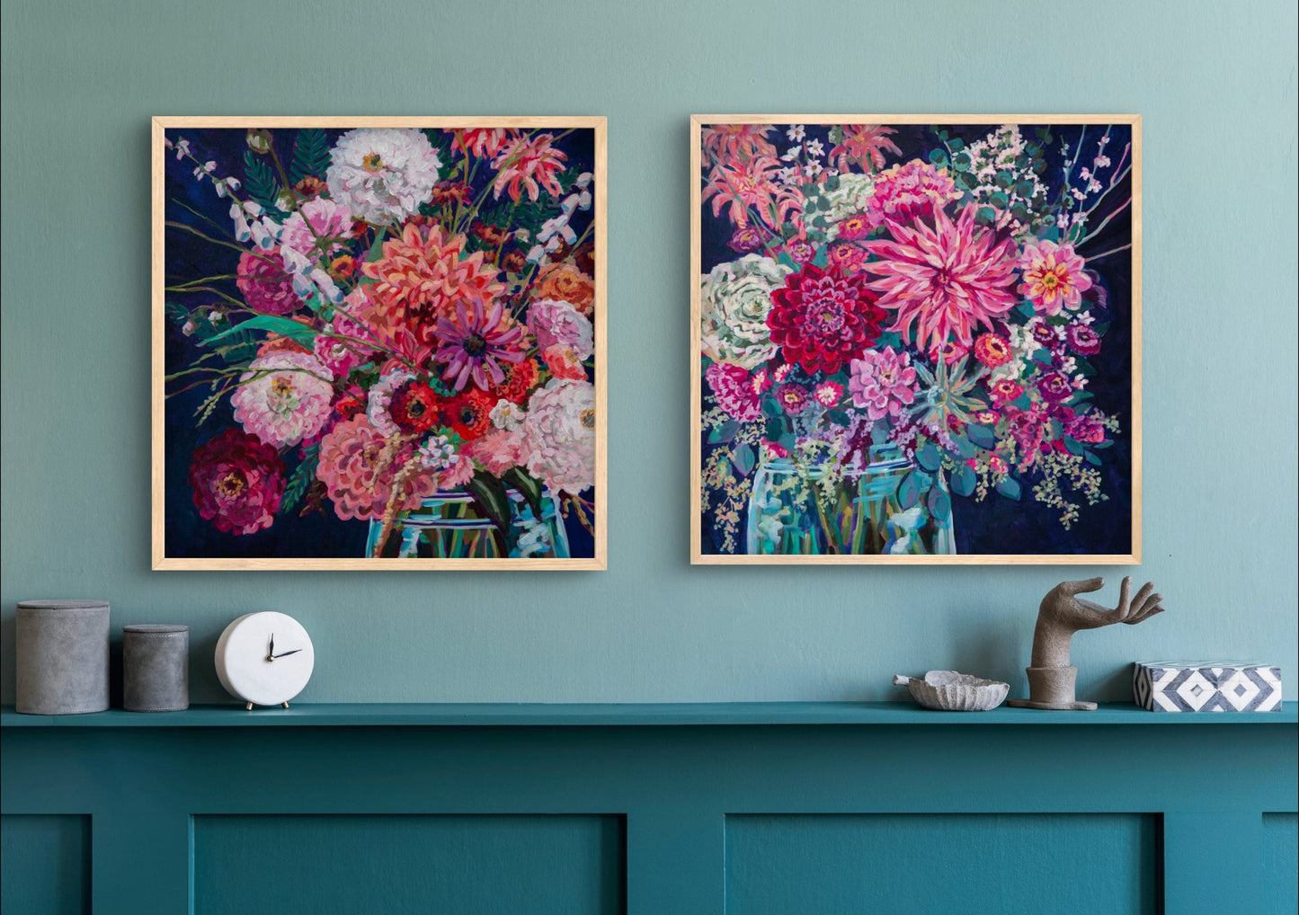 Room with teal shelf and decor and above it two still life paintings with vibrant flower arrangements tie room together