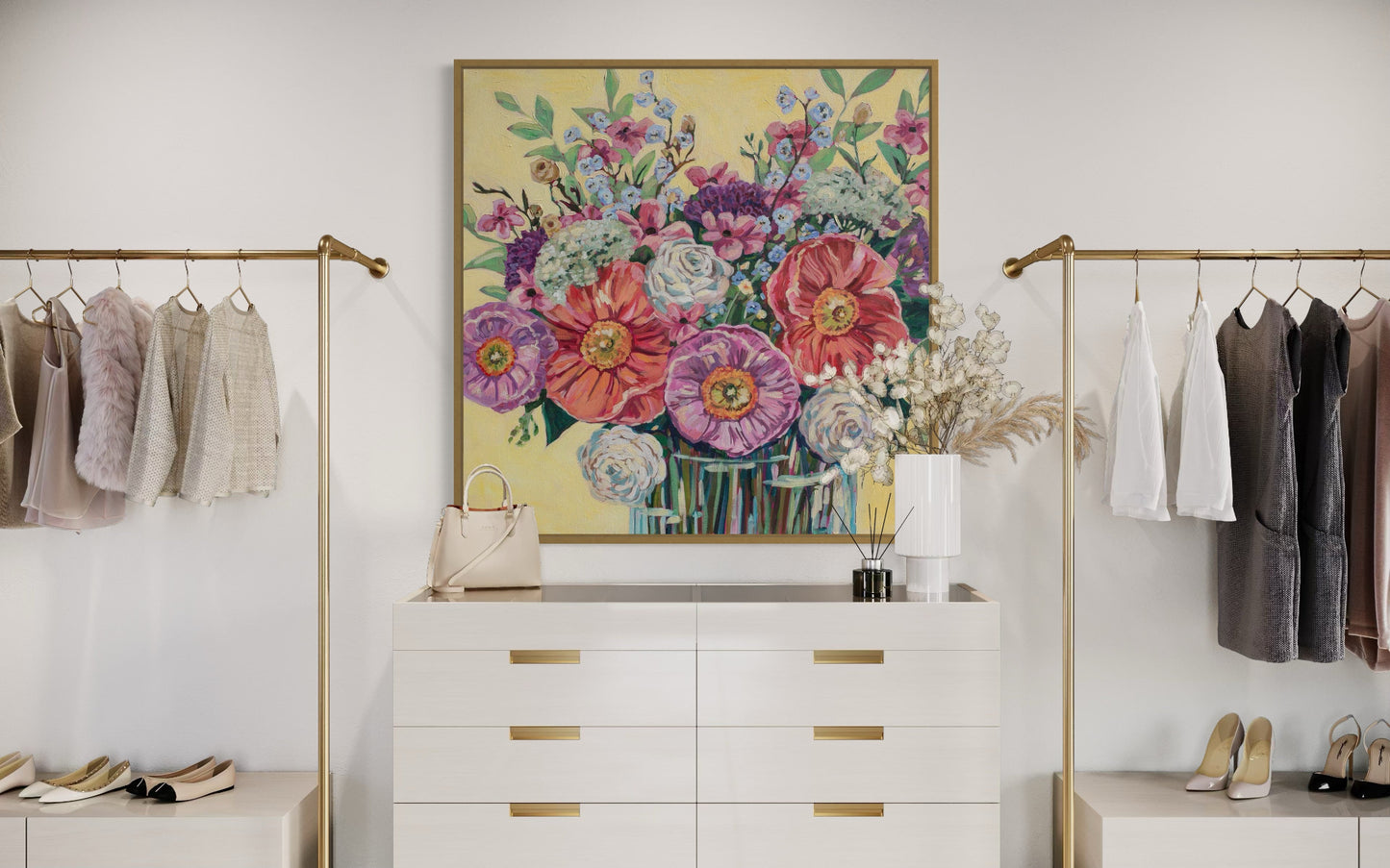 Room interior with floral artwork above a white dresser, flanked by clothing racks.