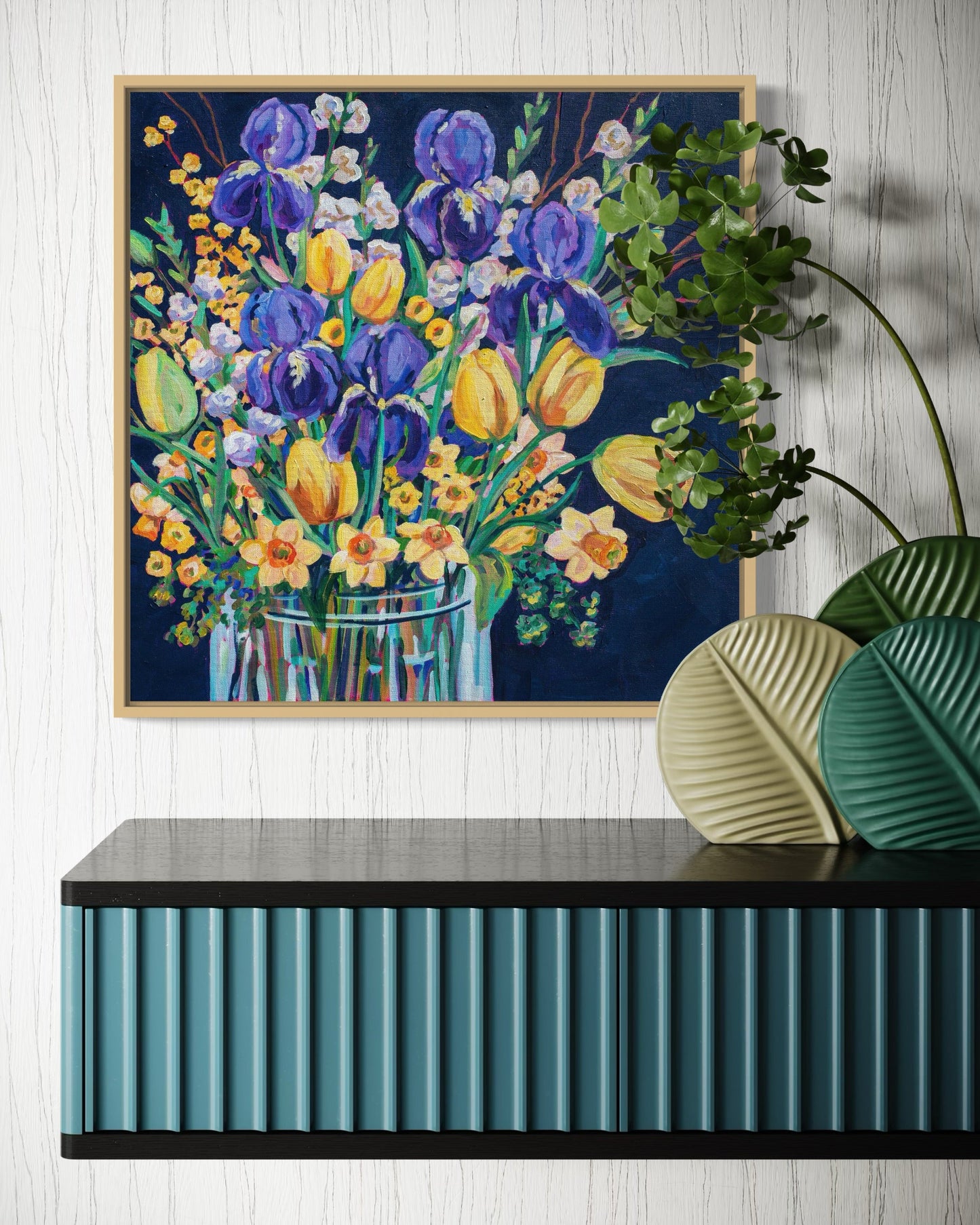 Framed floral painting on a wall above a decorative console table.