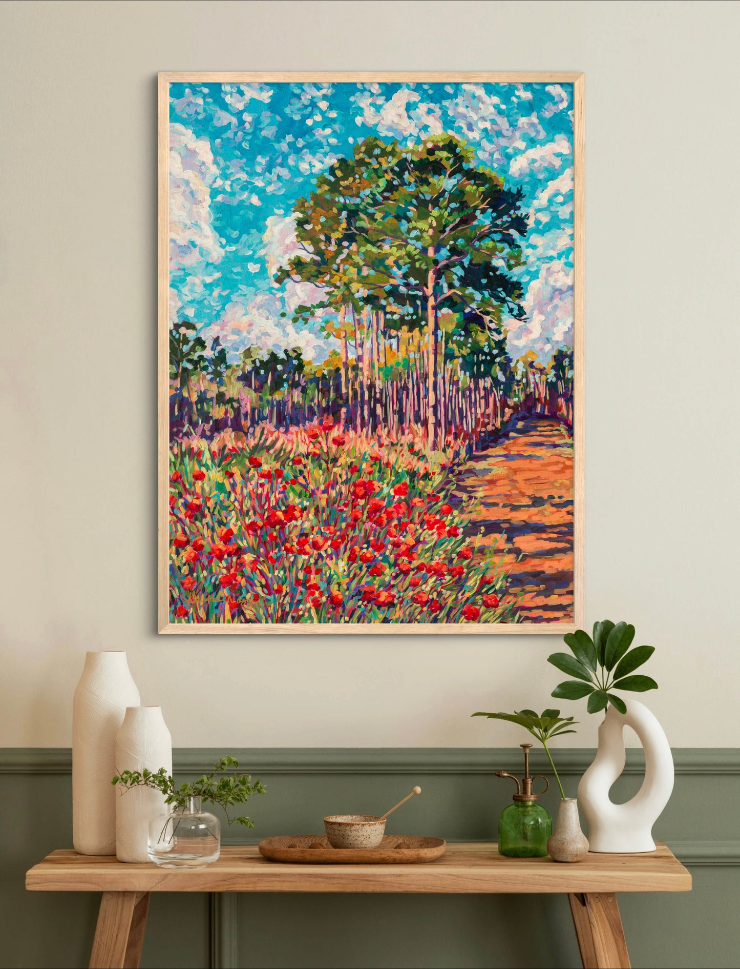 vibrant impressionist painting of park scene in Florida on wall above a small table with vases and plants.