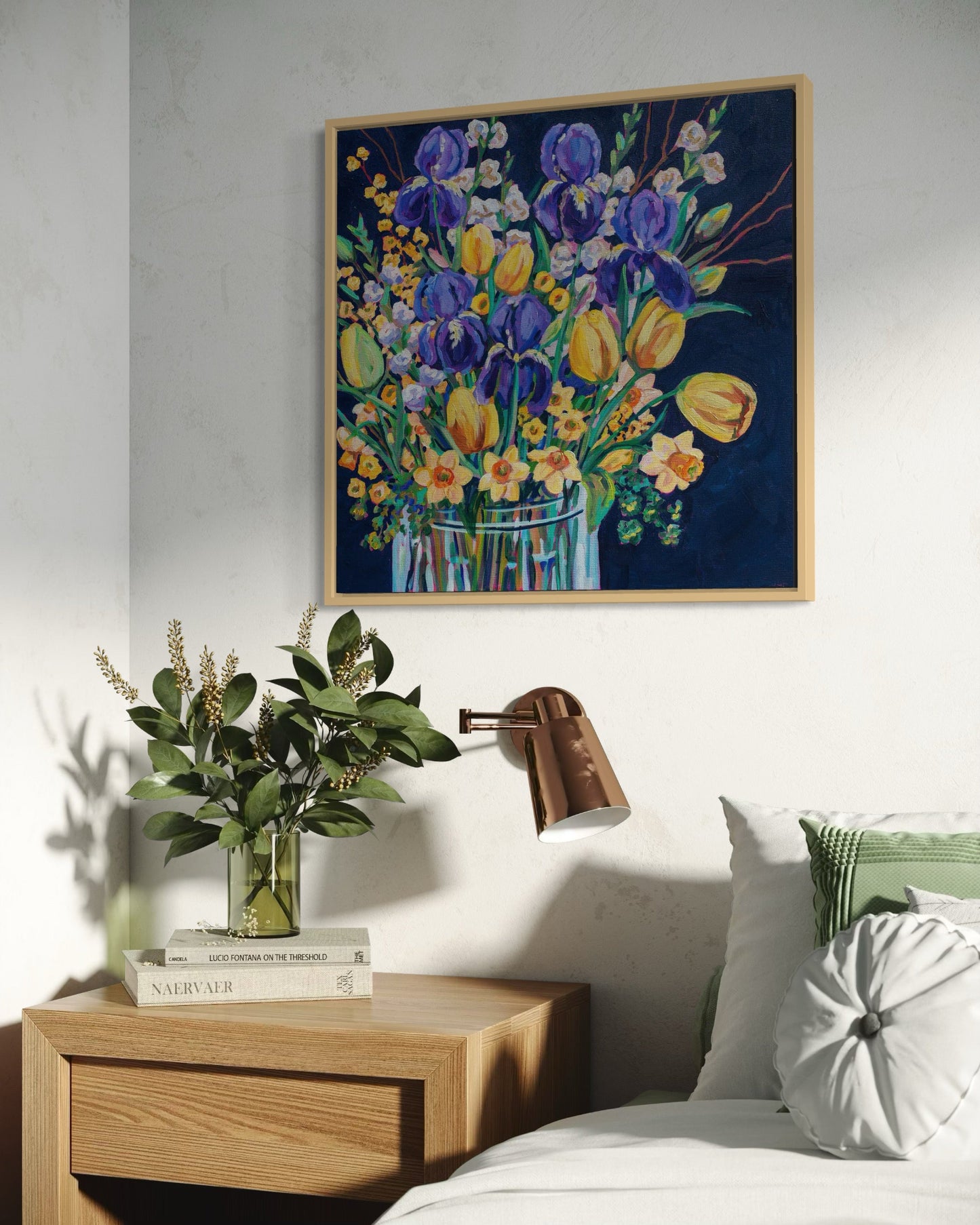 Framed floral painting in bedroom above a wooden nightstand with decorative items.