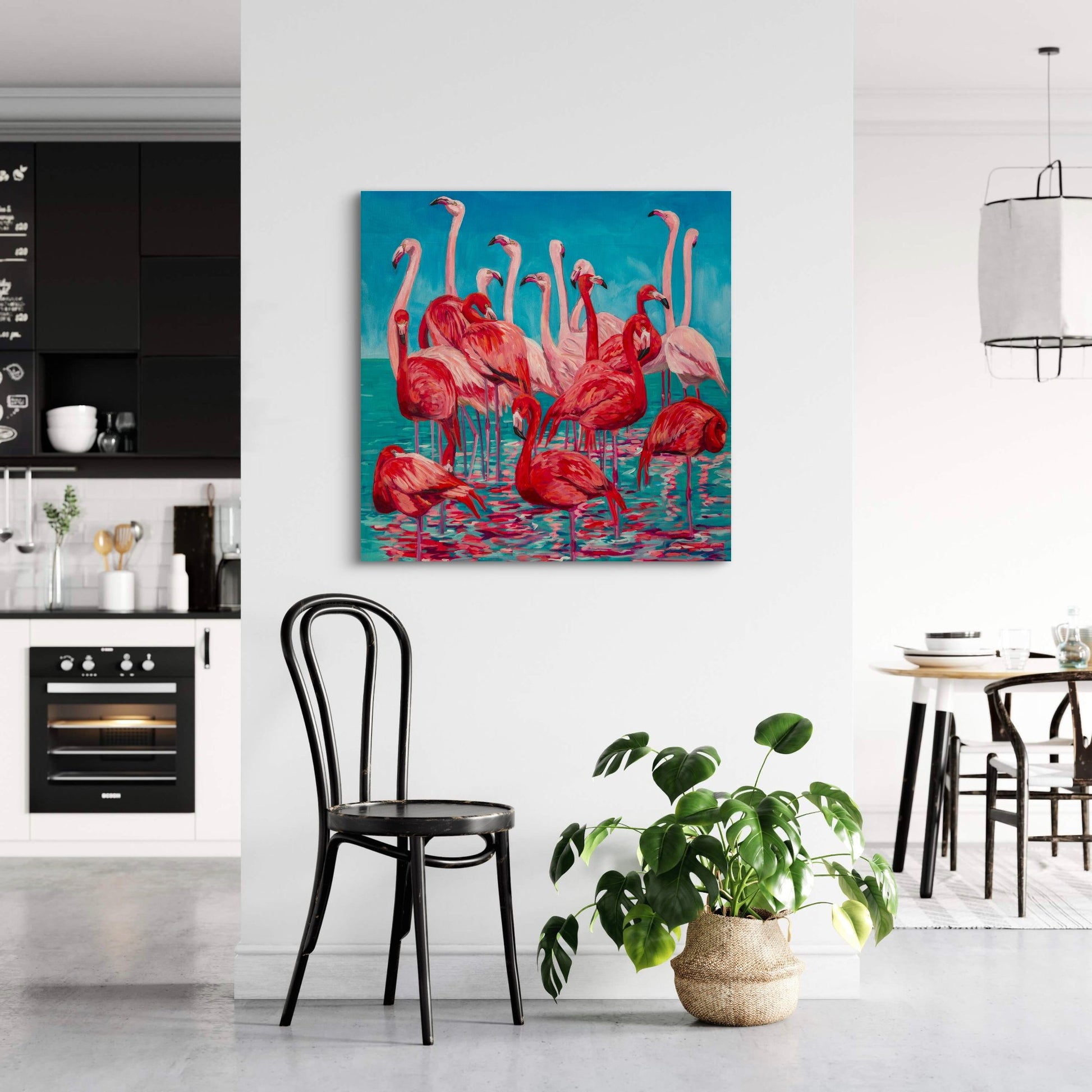 flamingo painting by artist Heather Nagy is focal point in a minimalist white kitchen/dining room with black accents.