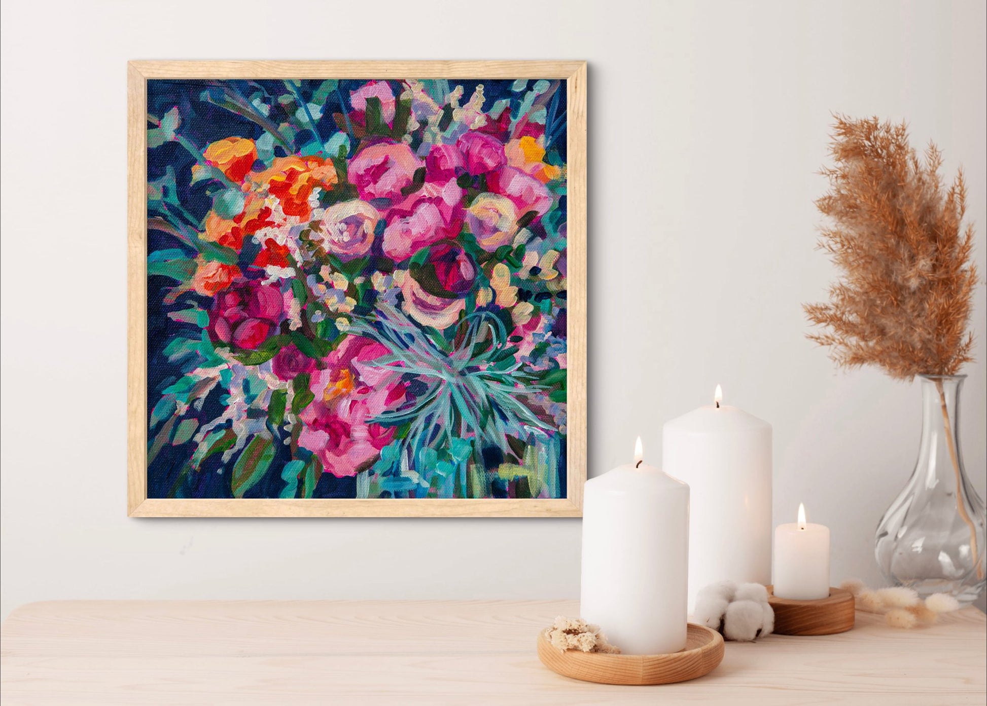 small square flower painting still life on wall above wood shelf with candles and vase in neutral  light wood colors.