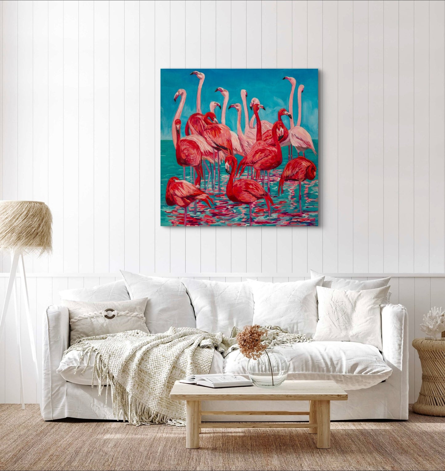 flamingo painting on wall above a creamy neutral light living room couch and coffee table.