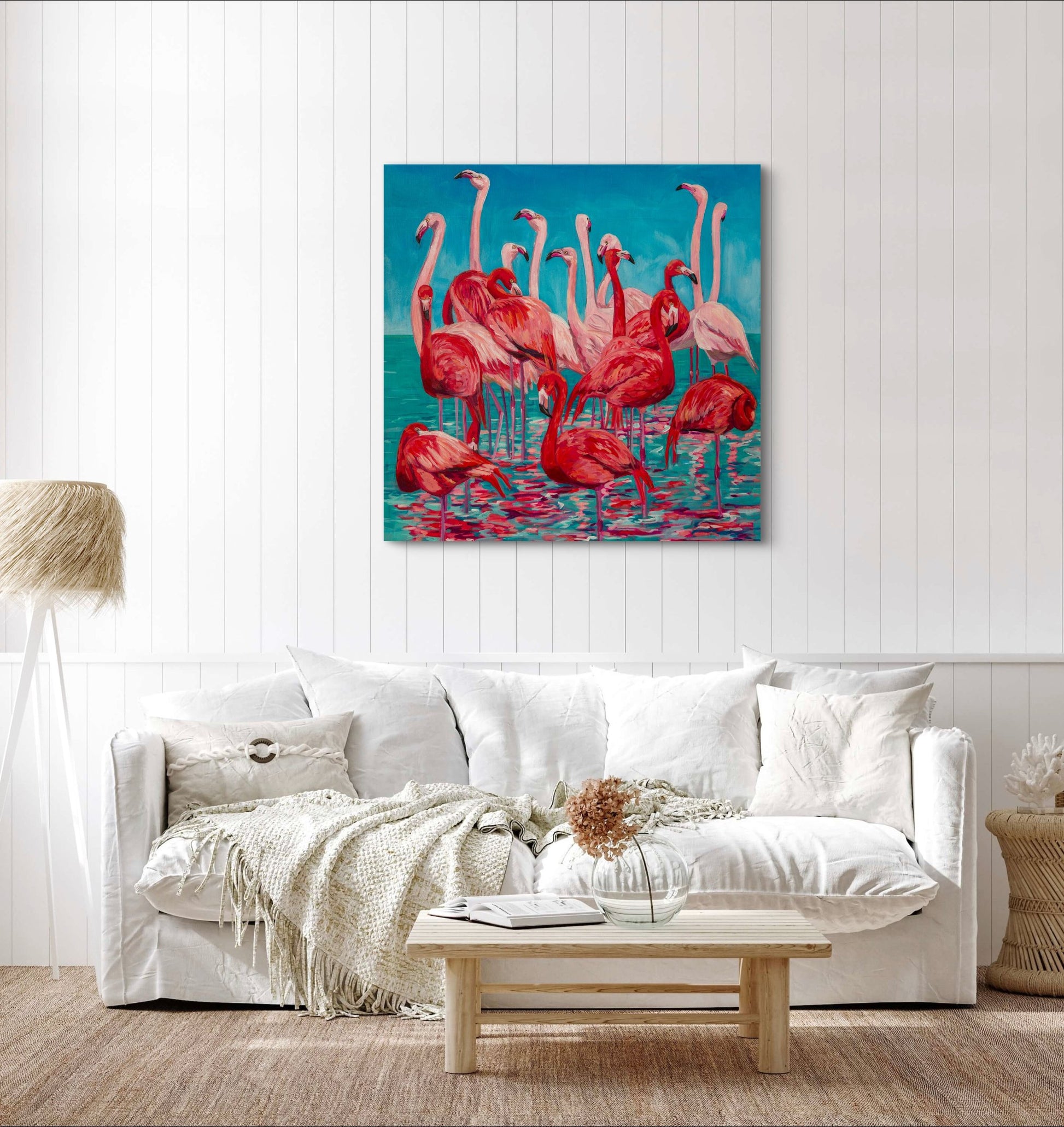 flamingo painting on wall above a creamy neutral light living room couch and coffee table.