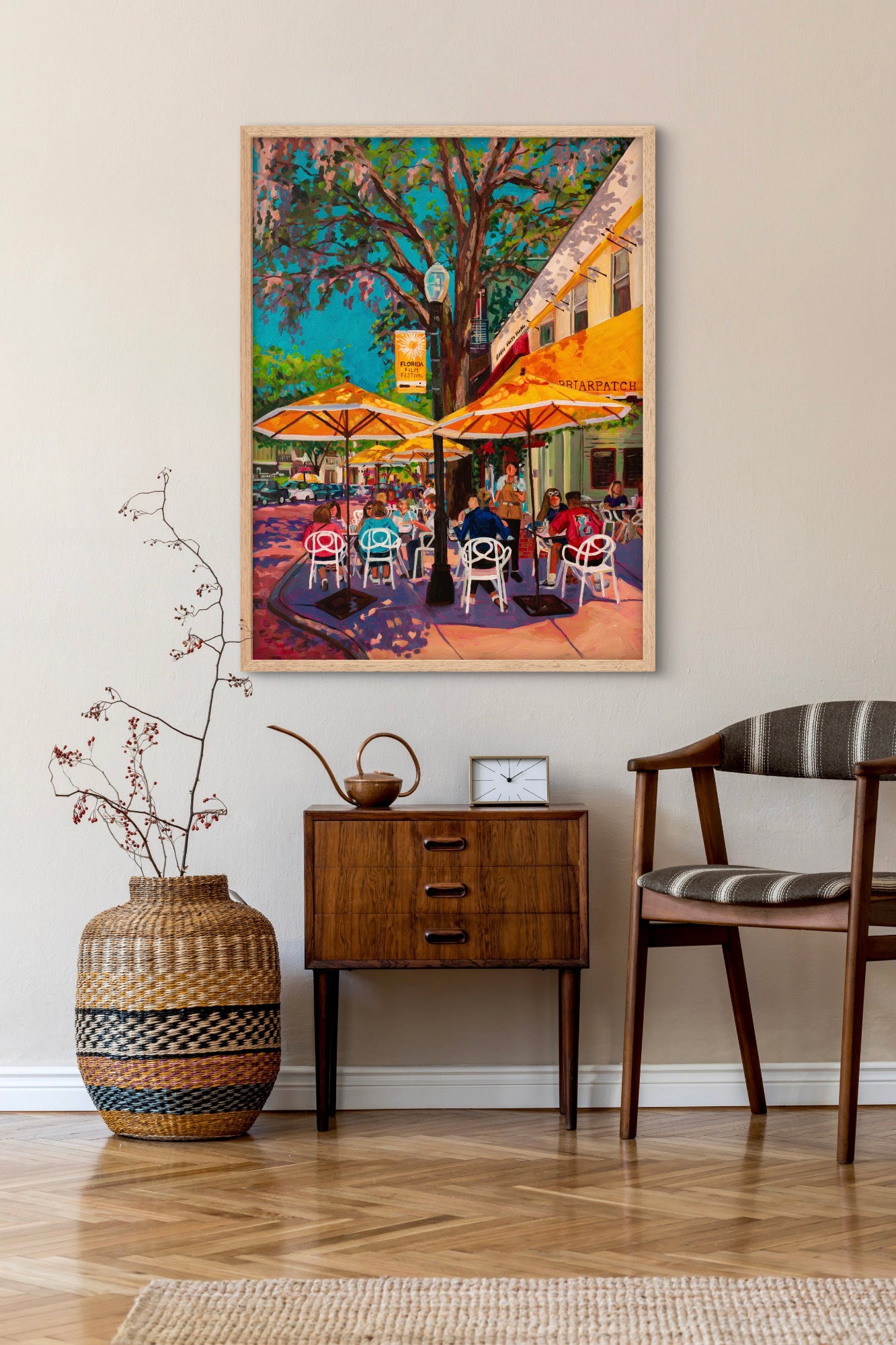 Clean entryway with table chair and vase and a modern vibrant painting of Winter Park Florida's iconic Briarpatch restaurants