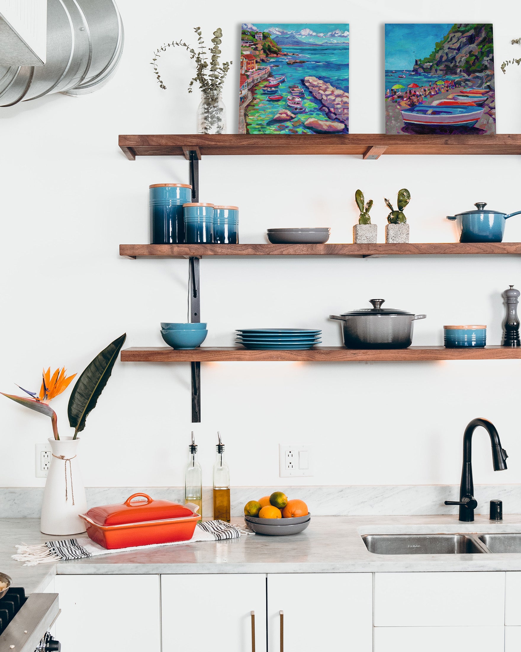 two italian sea scapes on shelf of modern kitchen