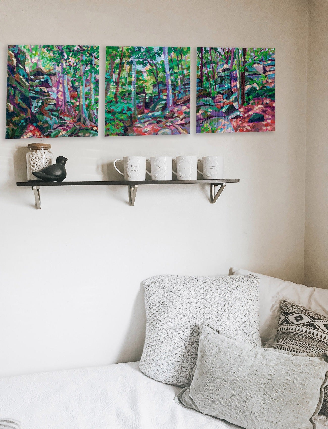 three paintings of Ledges area of Cuyahoga National Park on wall with shelf and bed