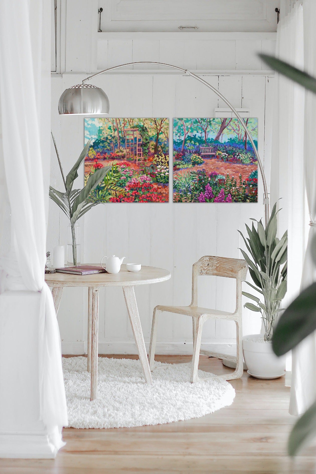 two garden paintings in small white dining space