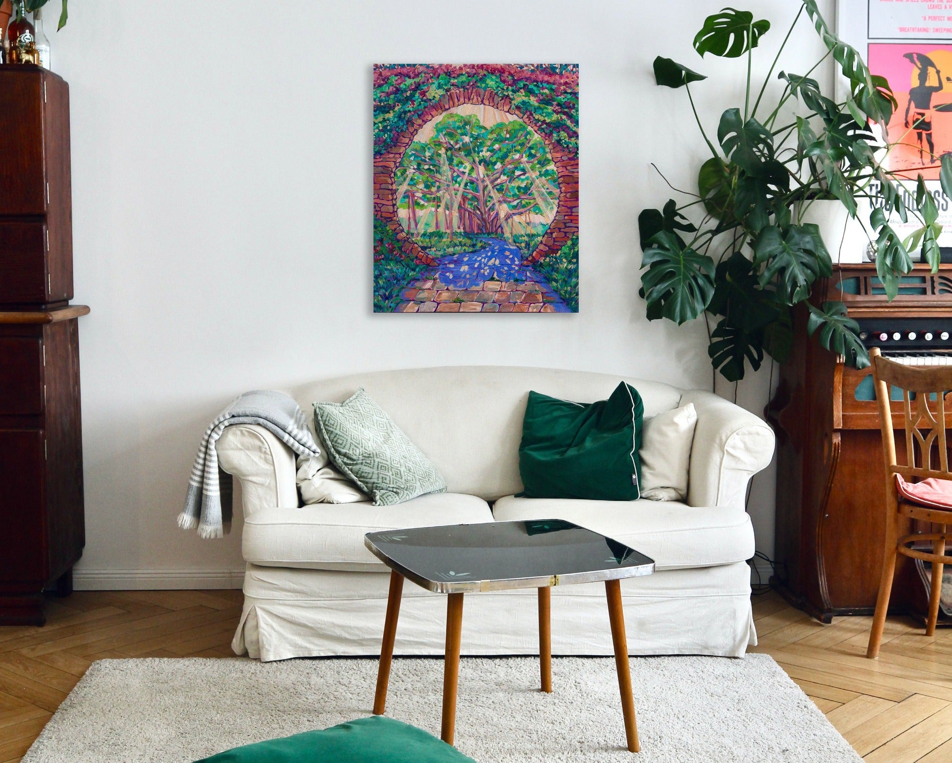 Painting in a living room setting with Original vibrant impressionistic painting of the Tree of Life and the Garden of Eden inspired by Revelation 2:7 with a Banyan tree and circle gate