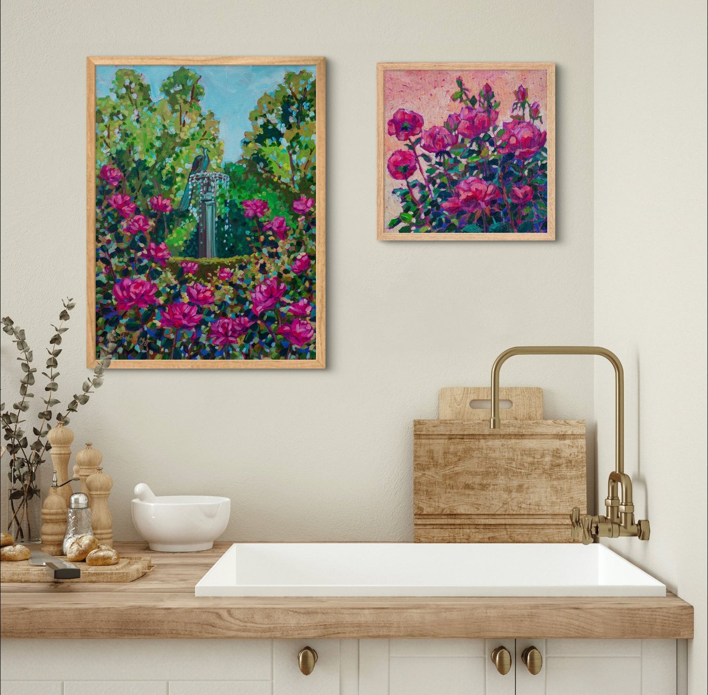 two vibrant fuchsia flower paintings over a neutral kitchen with sink and counter.