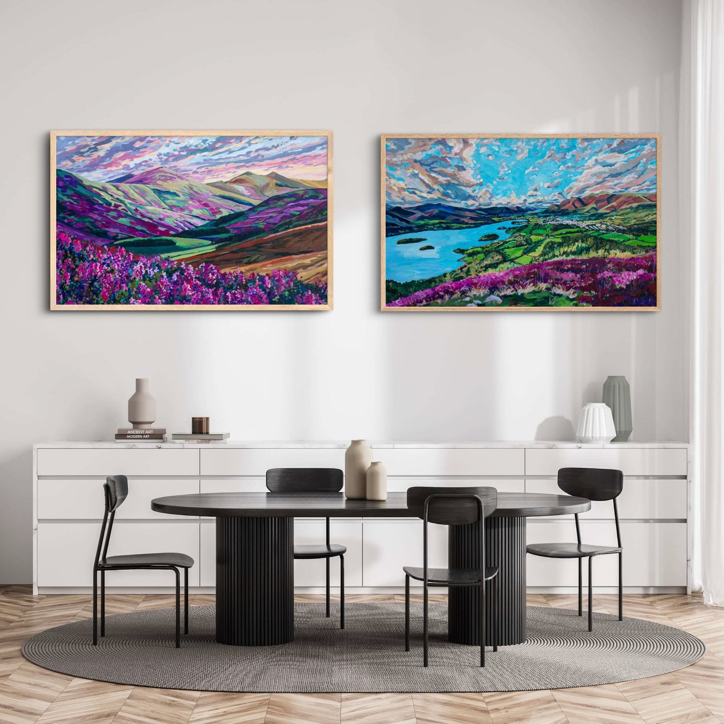 modern dining room in black and white with two large saturated vibrantly colorful landscapes, mountain scenes, english, Scottish, European paintings as centerpiece of room.