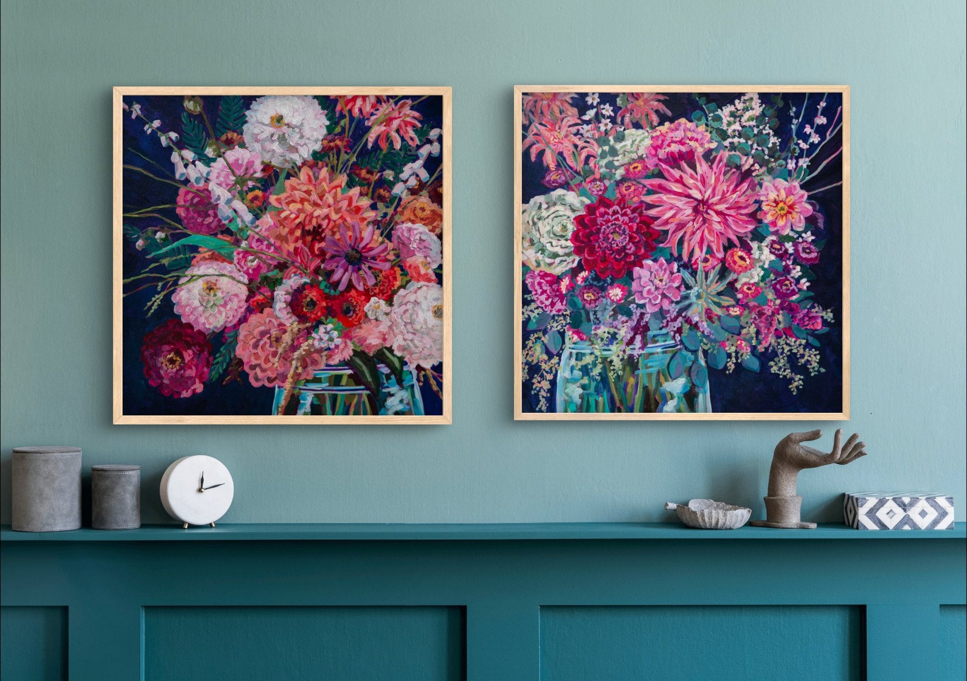 Room with teal shelf and decor and above it two still life paintings with vibrant flower arrangements tie room together 