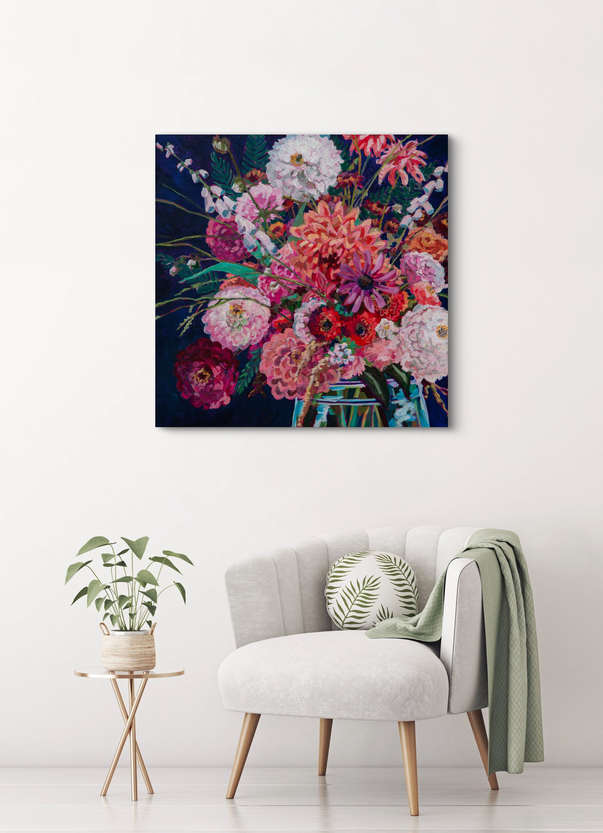 simple neutral room with white chair and green throw, small table with plant and vibrant statement piece painting of expressive floral arrangement.