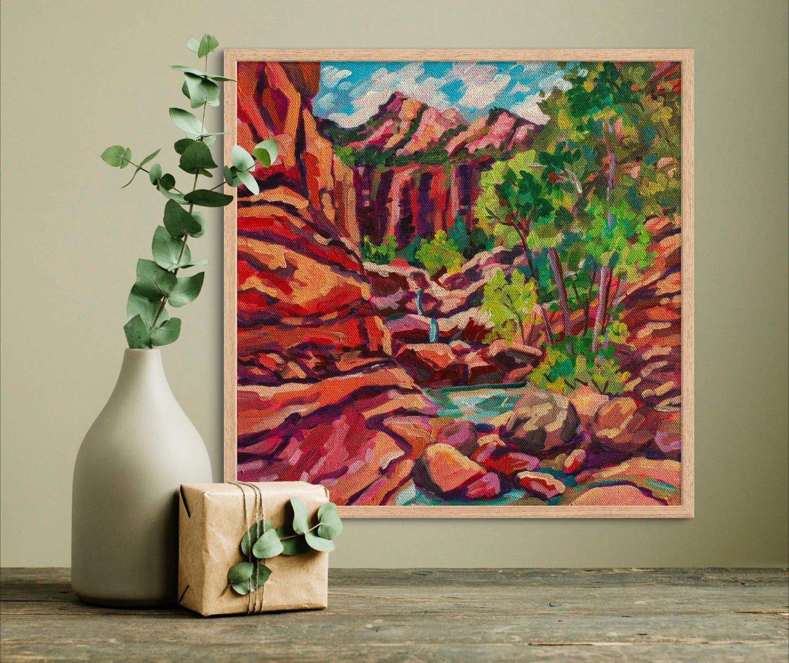 Painting of Zion National Park featuring red rocks in a small canyon with a waterfall and pools of water above a shelf with a vase and box.