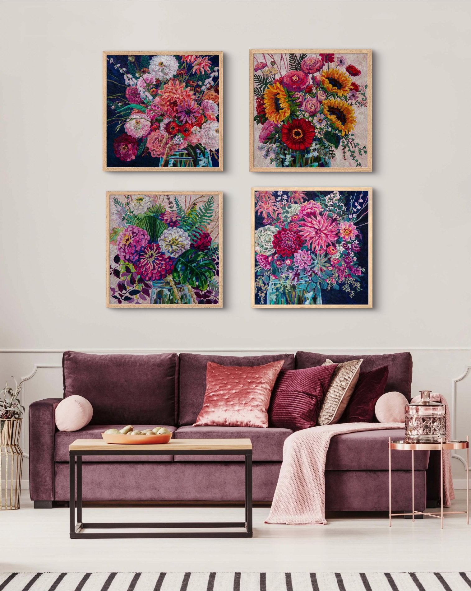 living room with velvet mauve couch and pink pillows and metal and wood coffee tables with grouping of 4 large floral still life paintings on wall, for chic modern style, color lovers, rich decor.