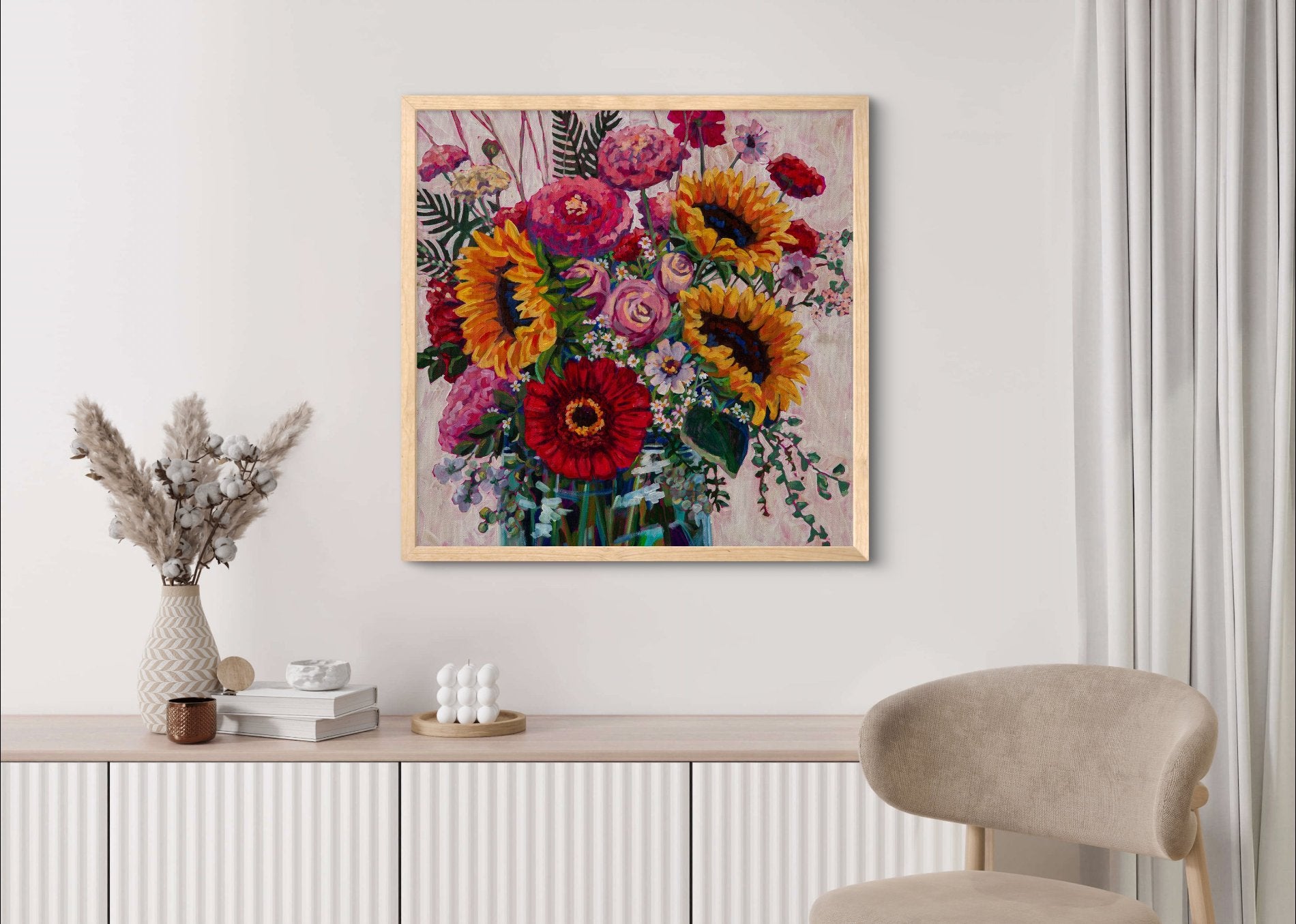 Framed painting of cheerful summer flowers in mason jar in cream room with chair and credenza shelf along wall with neutral decor