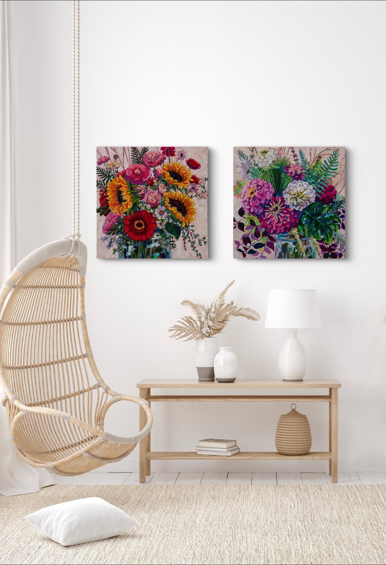 Bright white room with modern wicker chair hanging from ceiling and side table with decor and lamp and two modern bright expressive floral bouquet paintings on wall adding interest to the room