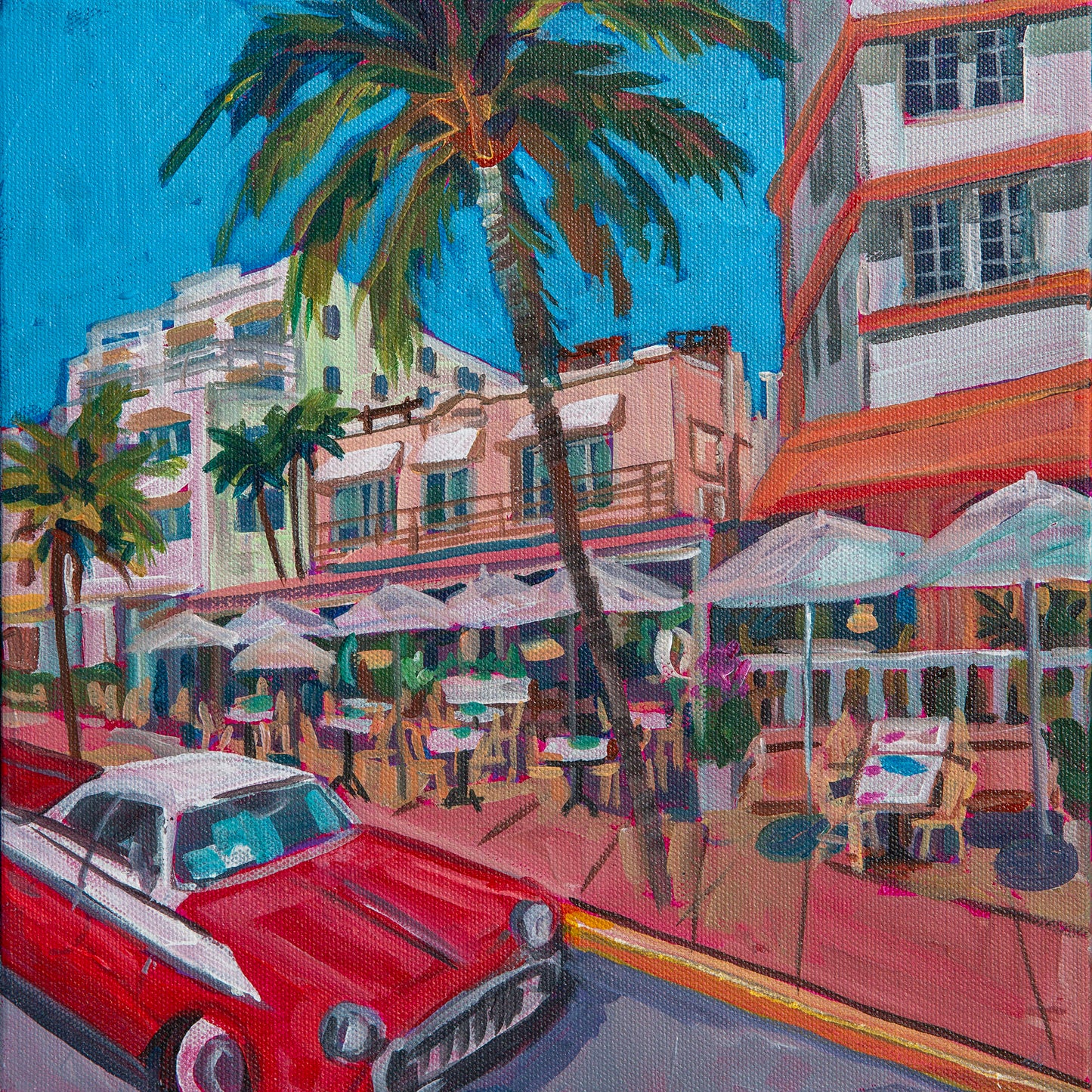 outdoor cafes along ocean ave in  South Beach Miami with umbrellas, art deco buildings and classic cars