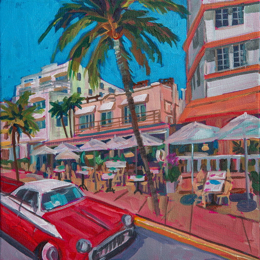 outdoor cafes along ocean ave in  South Beach Miami with umbrellas, art deco buildings and classic cars