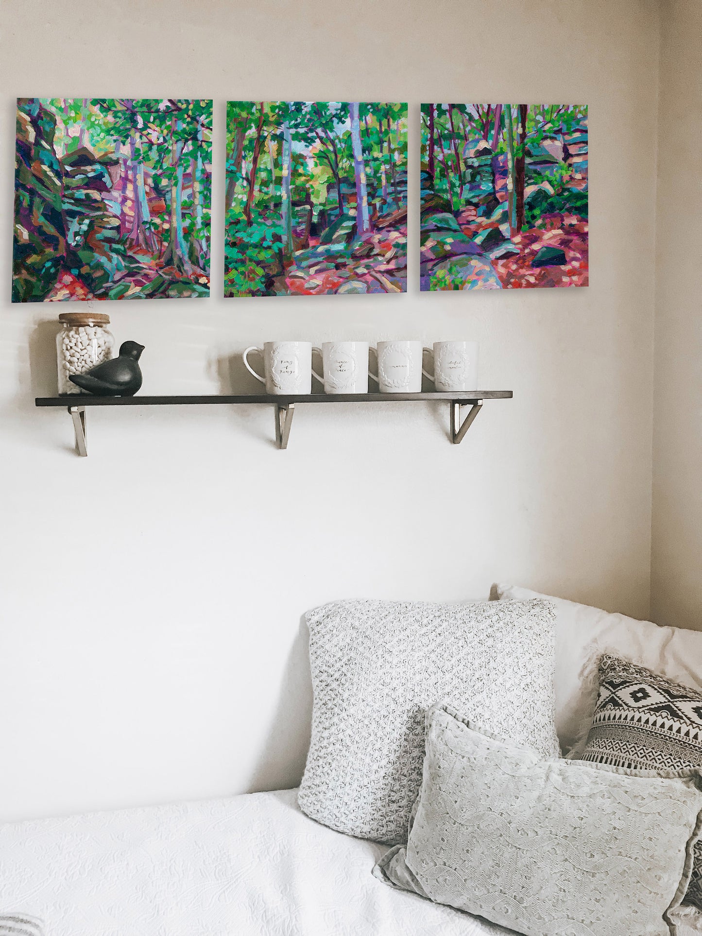 three small Cuyahoga ledges paintings in a row with shelf and bed