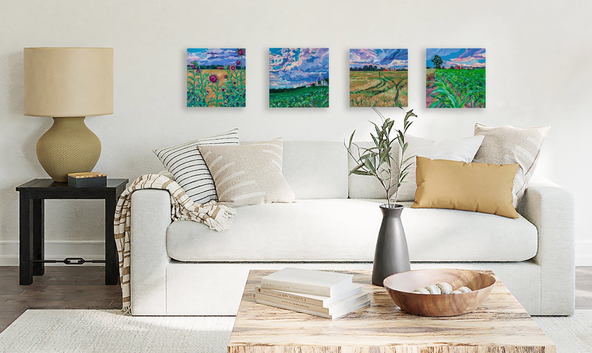4 different paintings from Michigan Farmland series on wall of neutral living room
