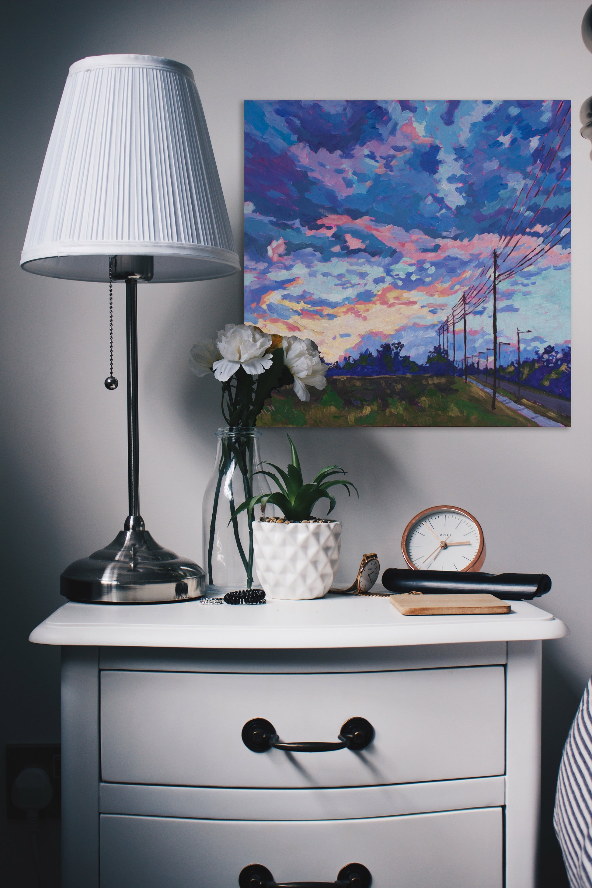 sunset painting by bedside table and lamp