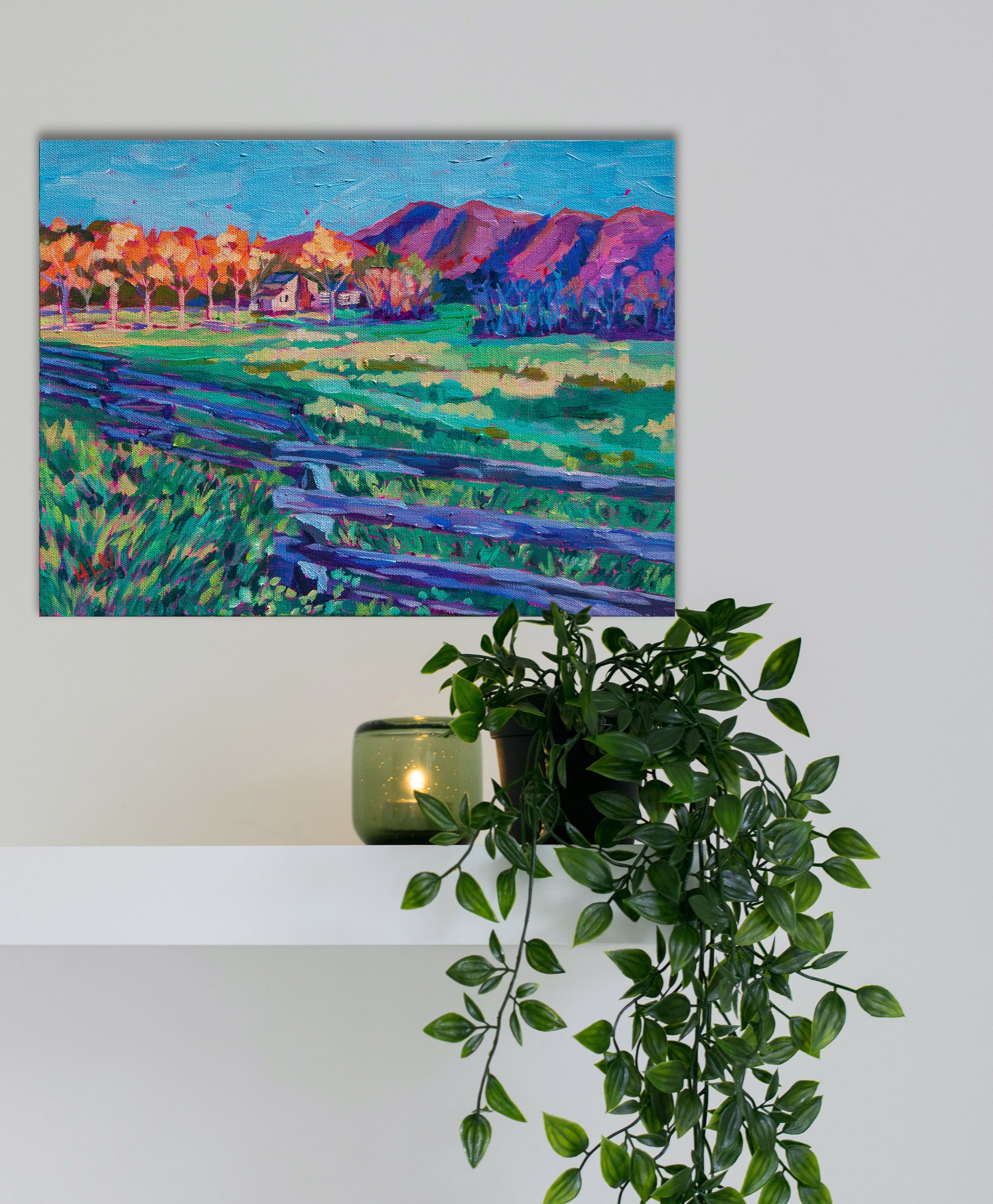 Original vibrant  impressionistic painting of smoky mountain national park on wall with shelf, plant and candle