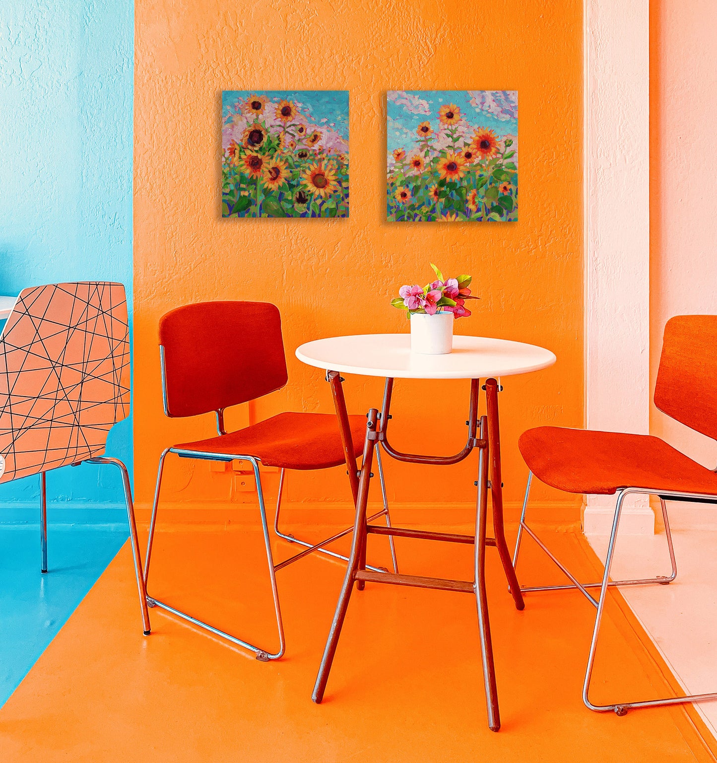 2 sunflower paintings in orange room with table and chairs
