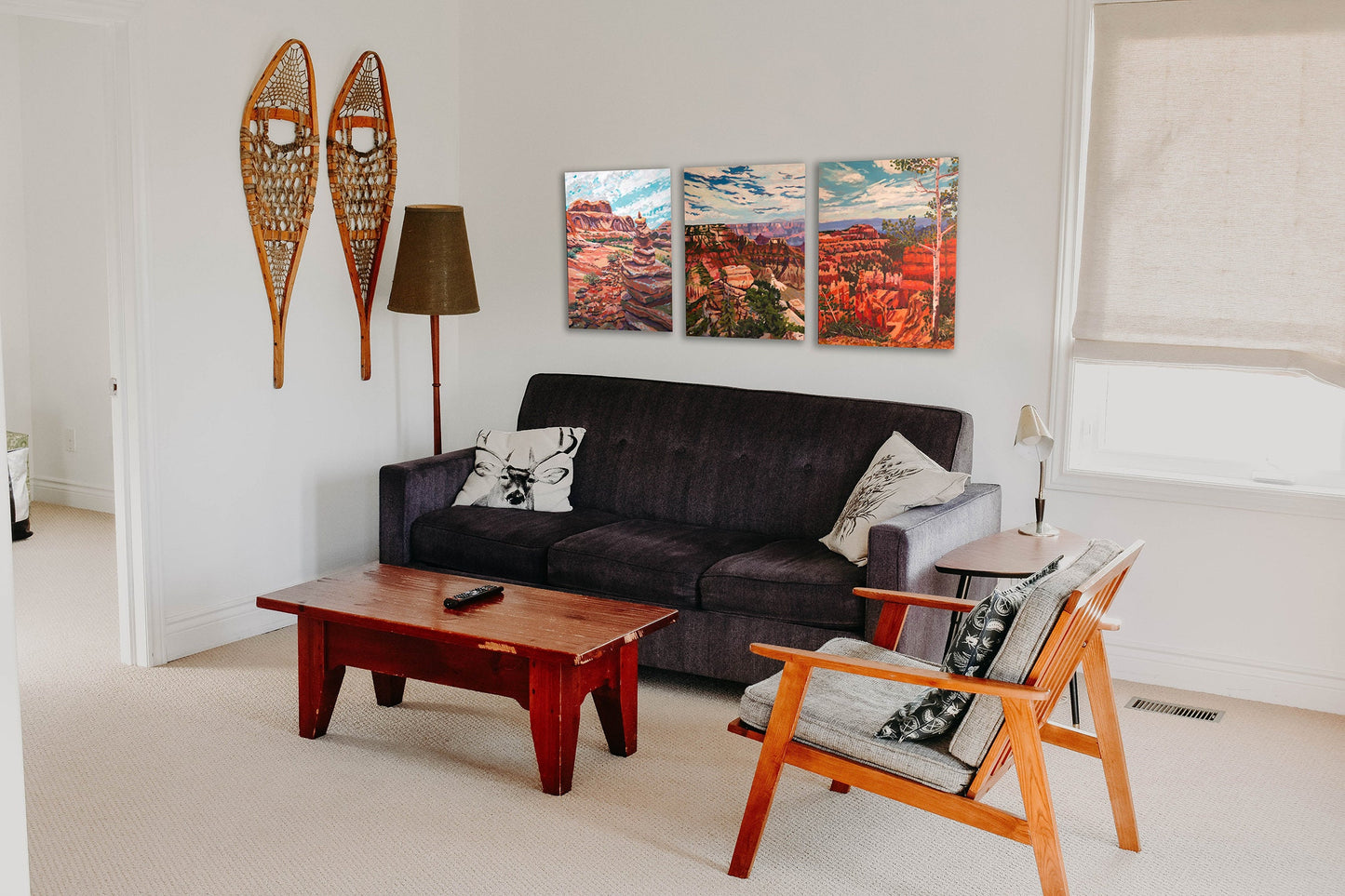 three southwest paintings in a rustic lving room