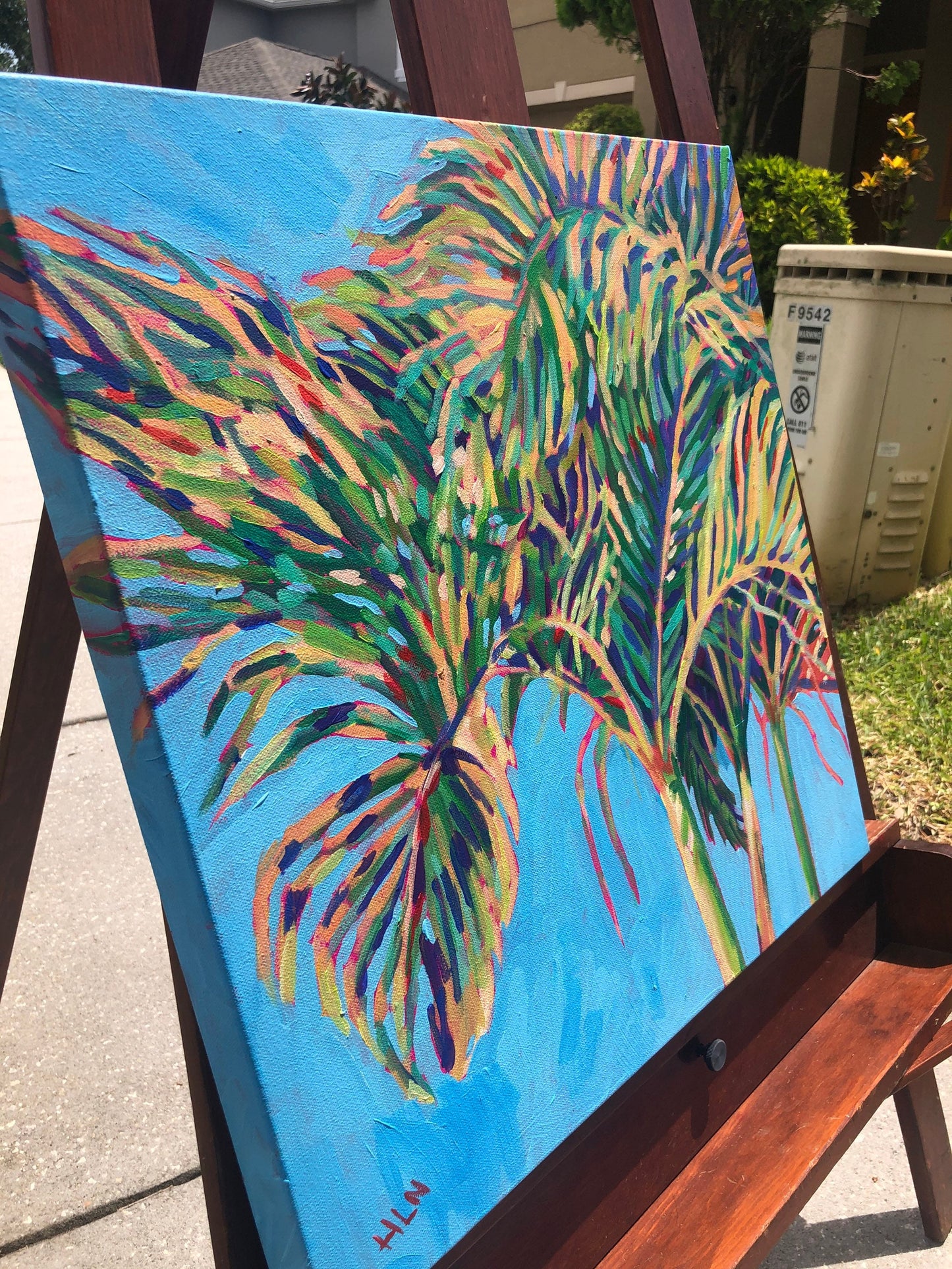 detail of palm tree painting outside on easel