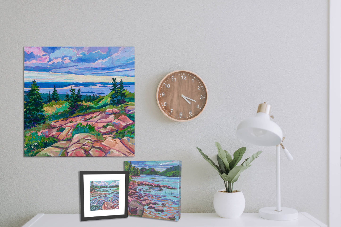 three Acadia National Park paintings with clock and lamp