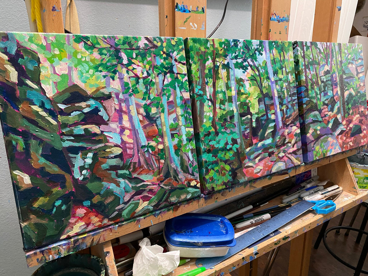 three paintings on easel together flowing into one another