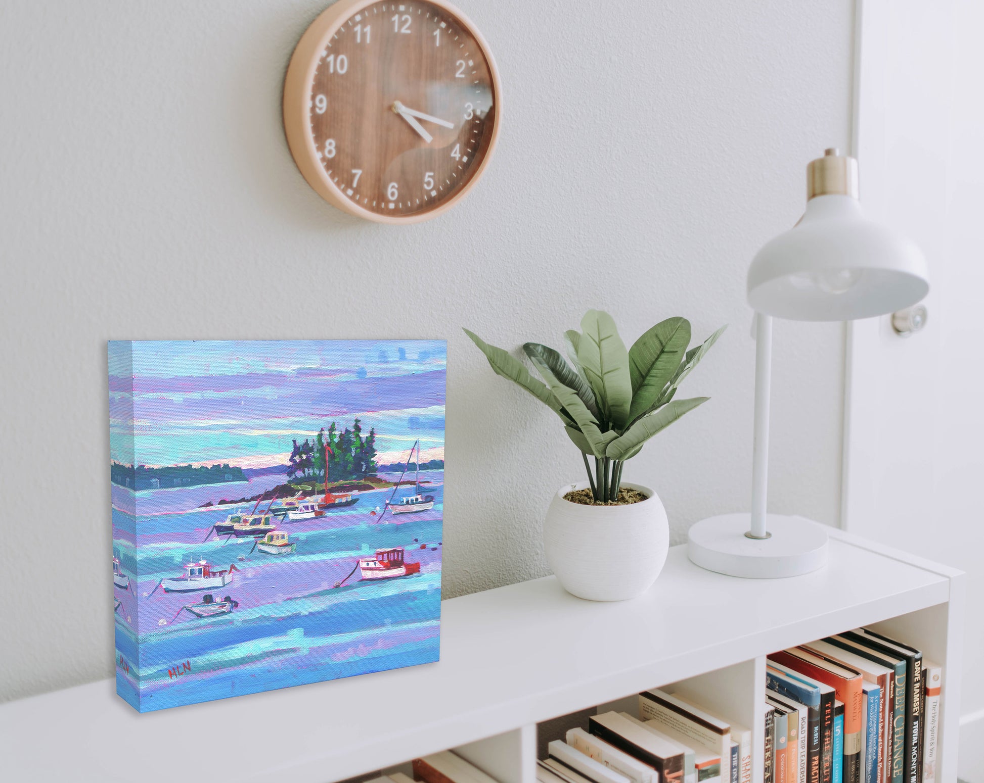 Lobster boats in harbor of Maine painting on bookshelf with clock