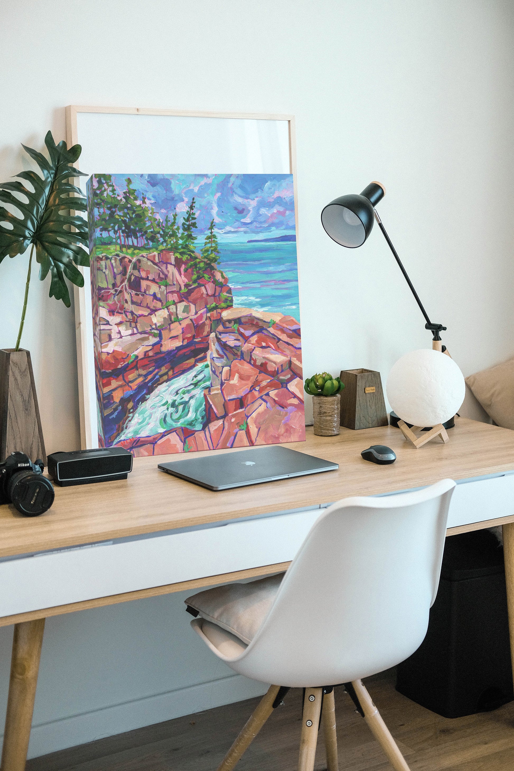 painting of Raven's nest sitting against wall on home office desk