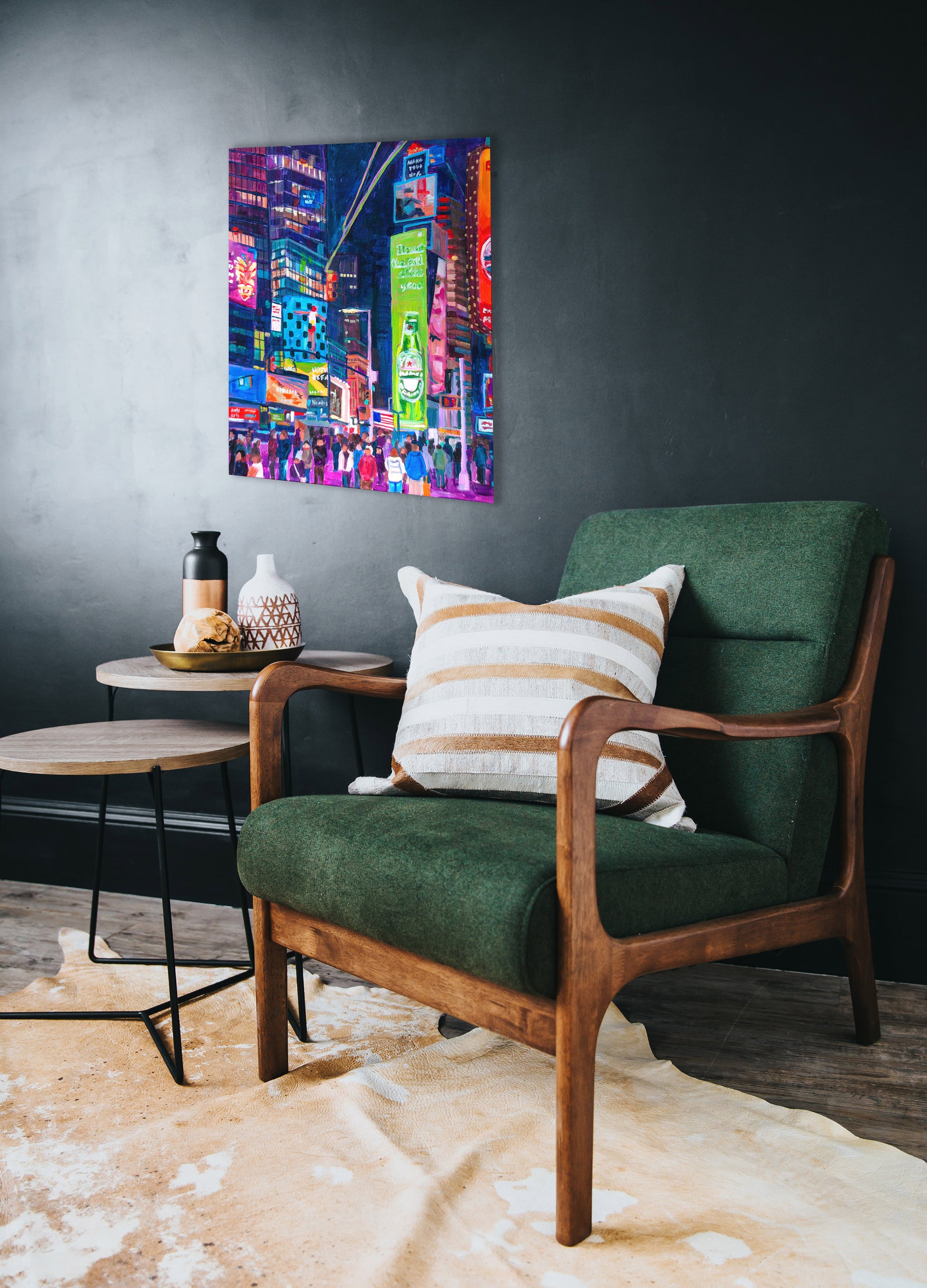 Painting of Time Square at night on wall with green chair and table